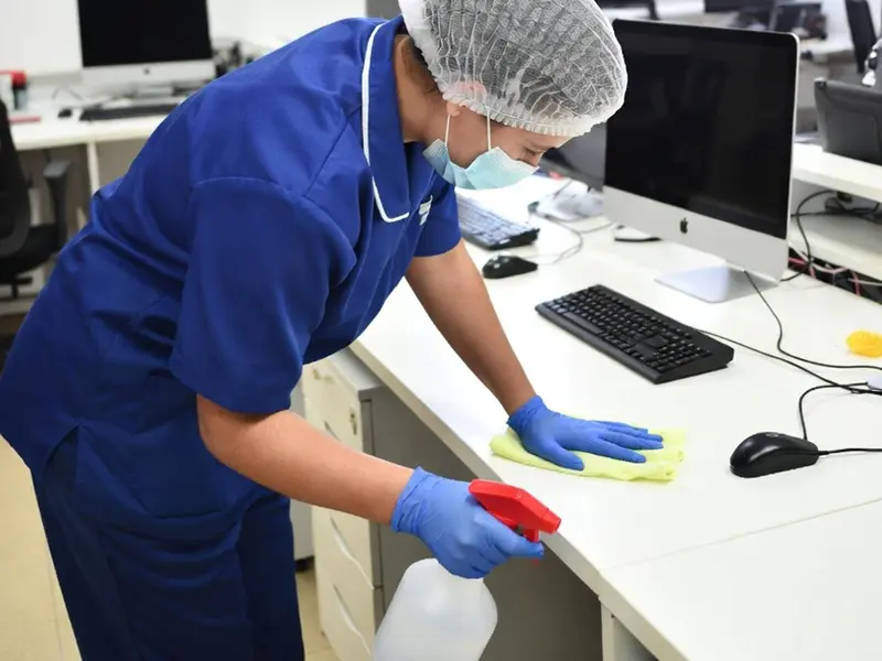 Professional cleaning a modern bathroom faucet.
